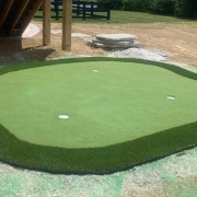 putting green installed in backyard landscaping design