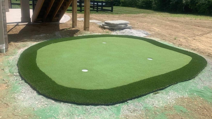 putting green installed in backyard landscaping design